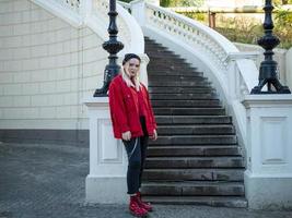 blonde in a red shoes standing near the stairs photo