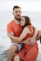 young couple in orange clothes with dog photo