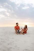 young couple in orange clothes with dog photo