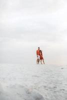 young couple in orange clothes with dog photo