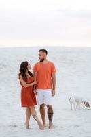 young couple in orange clothes with dog