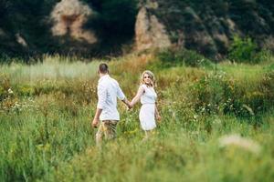 a guy with a girl in light clothes on the background of a green canyon photo