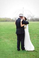 bride and groom on a rainy wedding day walking photo
