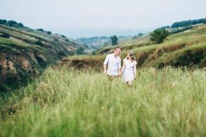 a guy with a girl in light clothes on the background of a green canyon photo