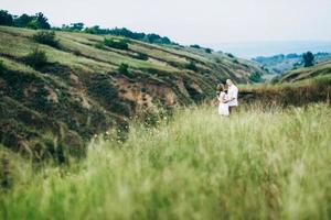 a guy with a girl in light clothes on the background of a green canyon photo