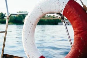 old lifebuoy in red and white on  the yacht photo