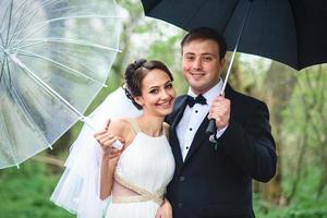 la novia y el novio en un día lluvioso de boda caminando foto