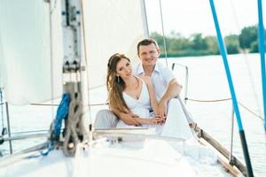 young couple guy and girl on a sailing yacht photo