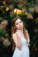 Happy girl in a turquoise long dress in a green park photo