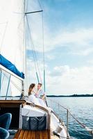 young couple guy and girl on a sailing yacht photo