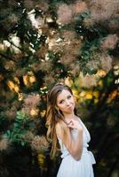 Happy girl in a turquoise long dress in a green park photo