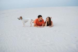 young couple in orange clothes with dog photo