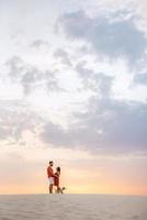 young couple in orange clothes with dog photo