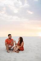 young couple in orange clothes with dog photo