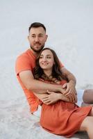 young couple in orange clothes with dog photo