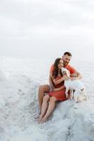 young couple in orange clothes with dog photo