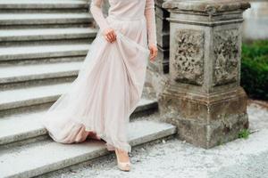 A girl in a light pink dress against the background of a medieva castle photo