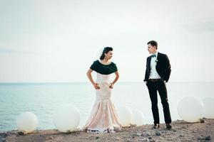 the groom in a brown suit and the bride in an ivory dress photo