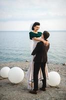 the groom in a brown suit and the bride in an ivory dress photo