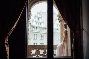 A girl in a light pink dress against the background of a medieva castle photo