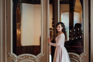 A girl in a light pink dress against the background of a medieva castle photo