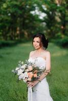 bride in a white dress with a large spring bouquet photo