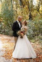 paseo de la novia y el novio por el bosque de otoño foto