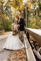 paseo de la novia y el novio por el bosque de otoño foto