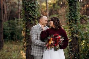 walk of the bride and groom through the autumn forest photo