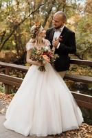 paseo de la novia y el novio por el bosque de otoño foto