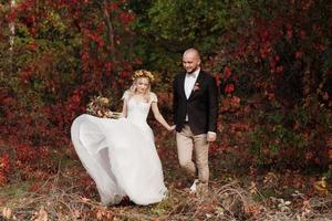 paseo de la novia y el novio por el bosque de otoño foto