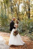 paseo de la novia y el novio por el bosque de otoño foto