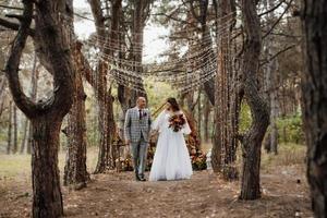 walk of the bride and groom through the autumn forest photo