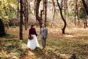 paseo de la novia y el novio por el bosque de otoño foto