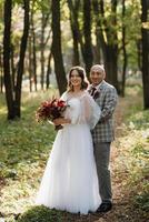 walk of the bride and groom through the autumn forest photo