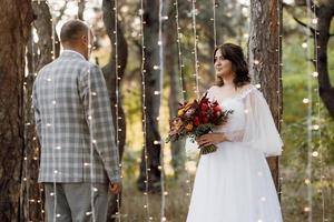 man and woman got engaged in autumn forest photo