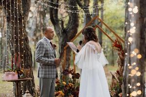 man and woman got engaged in autumn forest photo