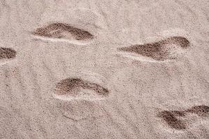 hoyos en la arena, causados por la huella de las personas foto