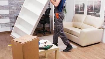 trabajador masculino revisando muebles nuevos después de terminar de ensamblarlos