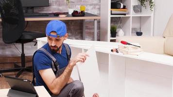 Attractive handyman assembles new furniture video