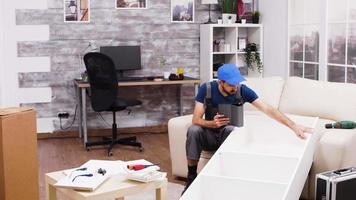 Worker using tablet computer to check instructions video