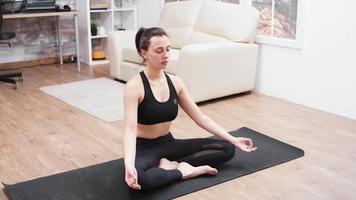entspannte junge Frau, die Meditation auf Yogamatte macht