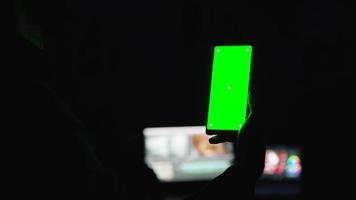 tenendo in mano uno smartphone con mock-up schermo verde video