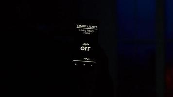 close-up da mão do homem segurando um aplicativo de luz inteligente com ativação por voz para acender as luzes da casa video