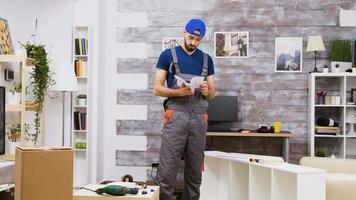 Furniture assembly worker standing reading instructions video