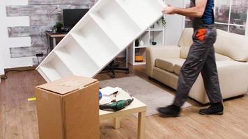 Fit male worker in overalls picks up furniture video