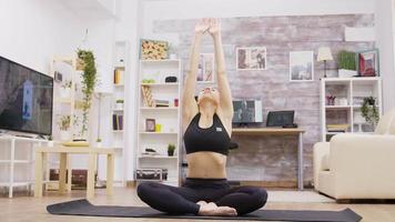 jonge volwassen vrouw doet yoga-meditatie in de woonkamer video