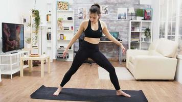 Calm young female practicing yoga exercises in living room video