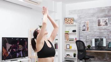 giovane donna concentrata che pratica yoga a casa video