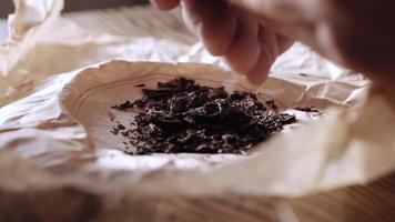 male hands touch tea leaves. softening pu-erh tea video